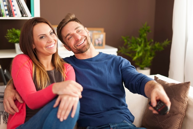 Feliz pareja viendo la televisión en casa