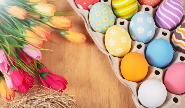 Feliz Pascua Colorido de huevos de Pascua y flor de tulipán sobre fondo de mesa rústica de madera