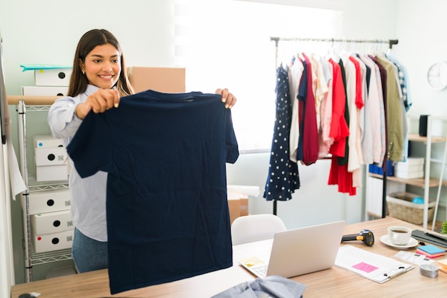 Feliz propietario de un negocio que vende ropa para hombres y mujeres en línea. Joven emprendedora que se siente orgullosa de su inicio de comercio electrónico