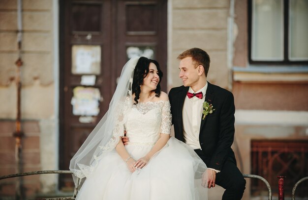 Feliz recién casados ​​posando sobre fondo urbano