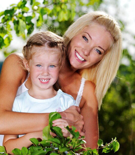 Feliz retrato de la madre y la pequeña hija al aire libre