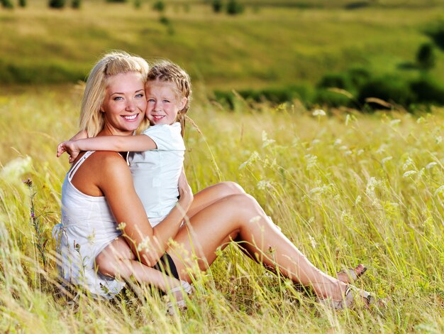 Feliz retrato de la madre y la pequeña hija en la pradera