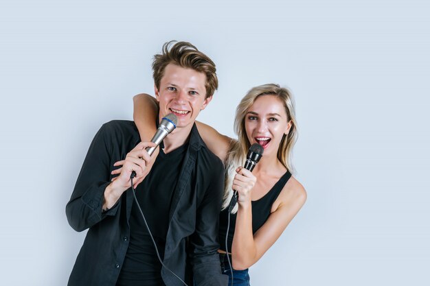 Feliz retrato de pareja con micrófono y canta una canción