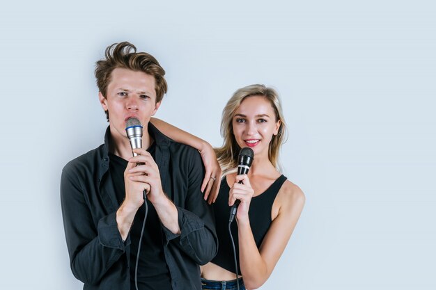 Feliz retrato de pareja con micrófono y canta una canción