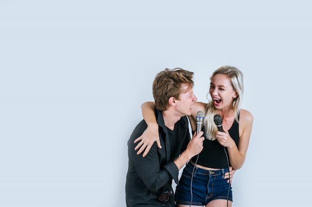 Feliz retrato de pareja con micrófono y canta una canción