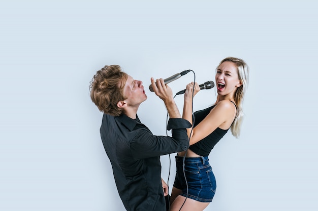 Feliz retrato de pareja con micrófono y canta una canción