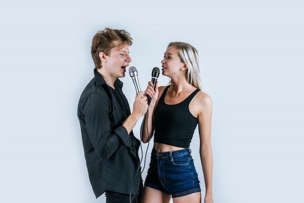 Feliz retrato de pareja con micrófono y canta una canción