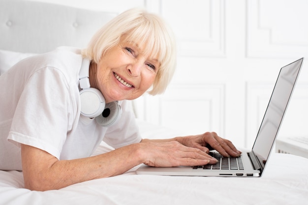 Feliz senior con auriculares y portátil