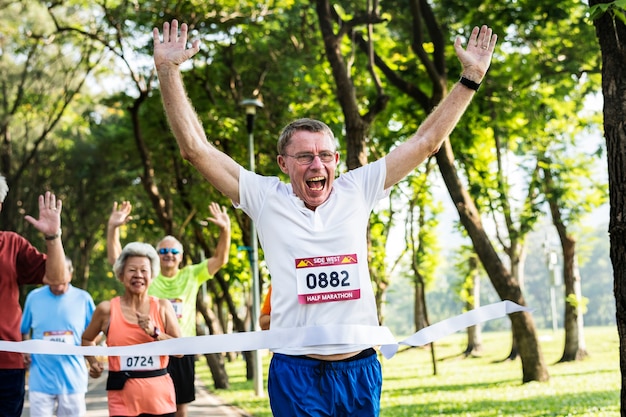 Feliz senior corriendo por la línea de meta