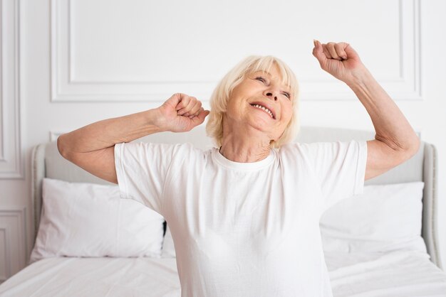 Feliz senior sentado en el dormitorio