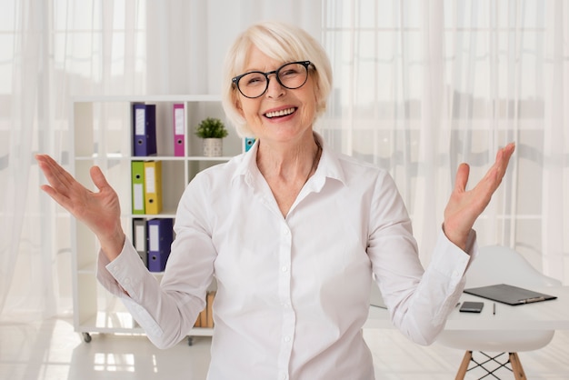 Foto gratuita feliz senior en su tiro medio de oficina