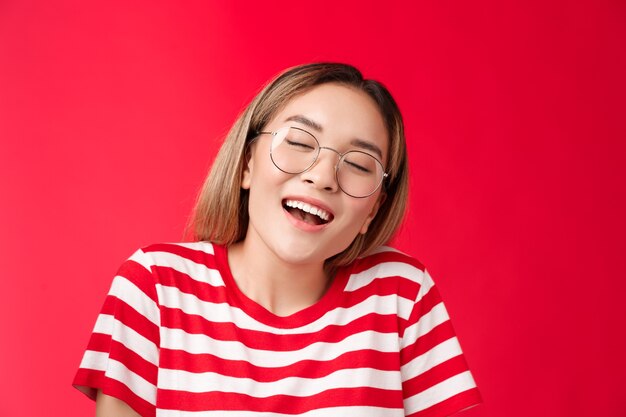 Feliz soñadora alegre niña asiática sentirse bien relleno después de comer sándwich favorito mujer usar gafas clo ...