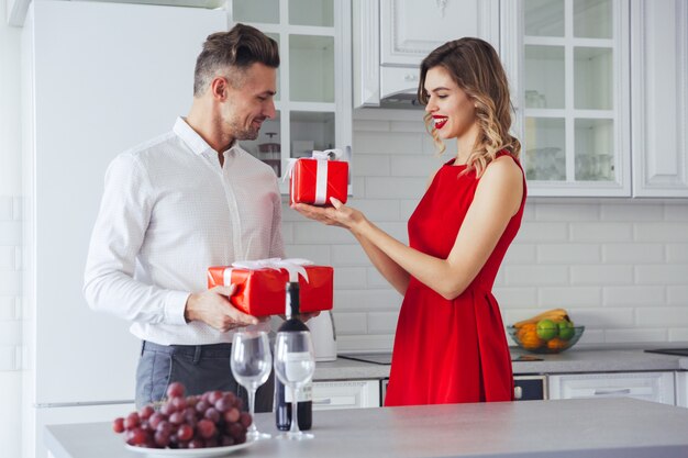 Feliz sonriente hombre y mujer dando presente el uno al otro en vacaciones