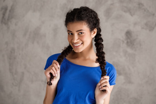 Foto gratuita feliz sonriente mujer adolescente con trenzas