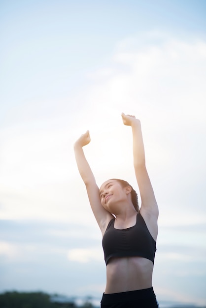 Feliz sonriente mujer atlética con los brazos extendidos