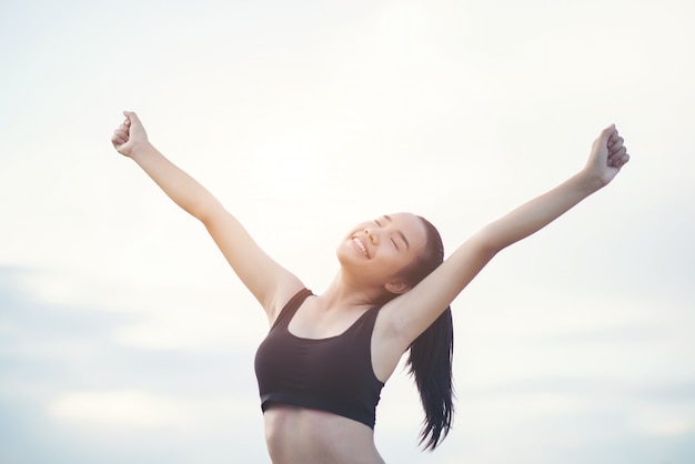 Feliz sonriente mujer atlética con los brazos extendidos