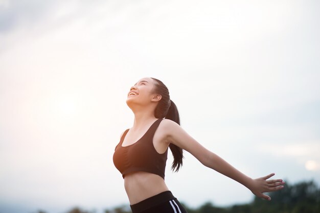 Feliz sonriente mujer atlética con los brazos extendidos