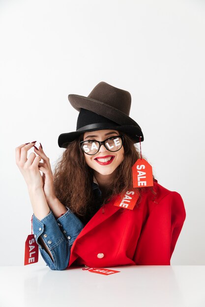 Feliz sonriente mujer de venta sentada con bolsas de papel