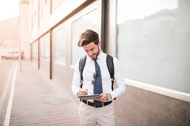 Feliz turista masculino con tableta digital