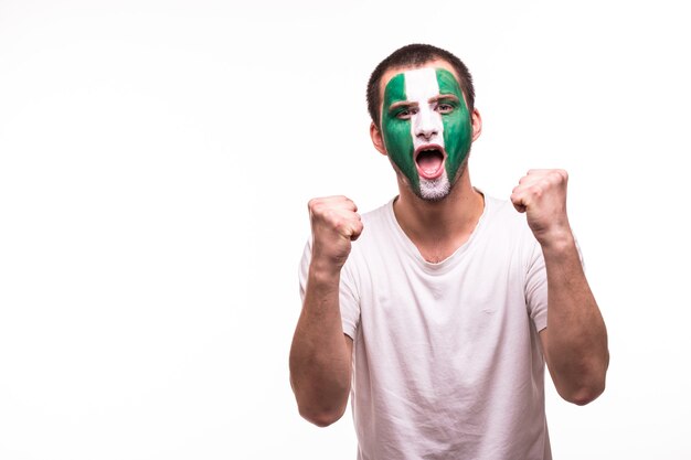 Feliz victoria grito hombre ventilador apoyo equipo nacional de Nigeria con cara pintada aislado sobre fondo blanco.