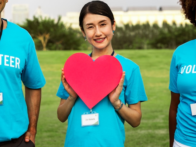 Feliz voluntario japonés con un corazón