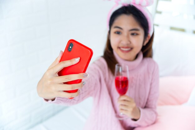 Felizmente adolescente disfrutando selfie con vino tinto en mano
