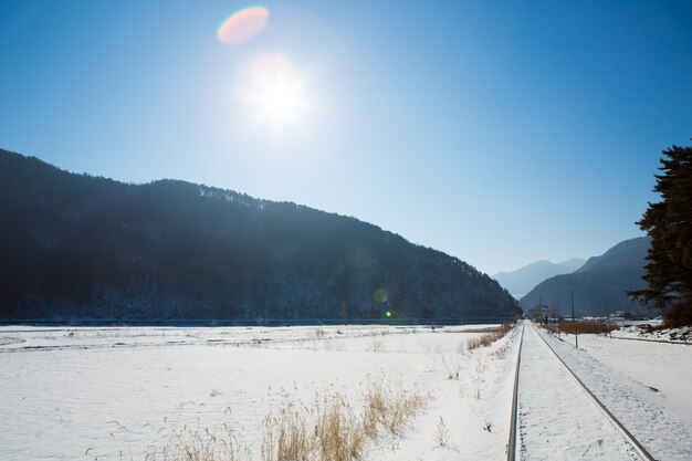 Ferrocarril en invierno con el sol