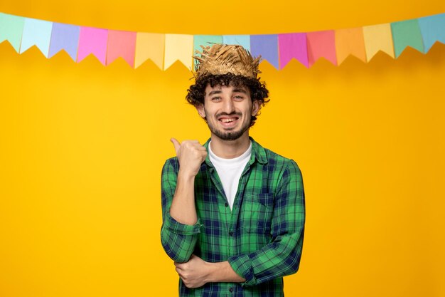 Festa junina chico lindo joven en sombrero de paja y banderas coloridas festival brasileño emocionado