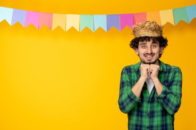 Festa junina chico lindo joven en sombrero de paja y banderas coloridas festival brasileño emocionado