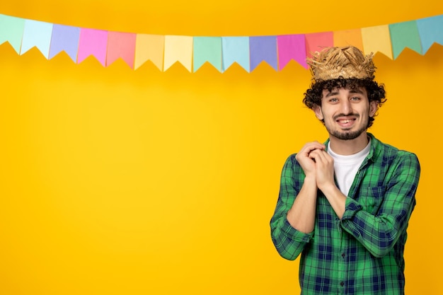 Festa junina chico lindo joven en sombrero de paja y banderas coloridas festival brasileño feliz