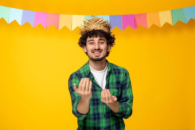 Festa junina chico lindo joven en sombrero de paja y banderas coloridas festival brasileño invitando con las manos