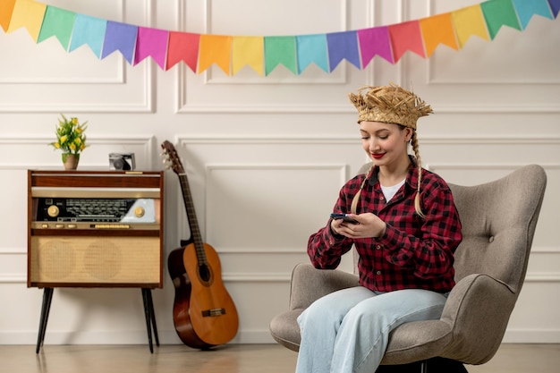 Festa junina linda chica con sombrero de paja verano brasileño con radio retro guitarra enviando mensajes de texto por teléfono