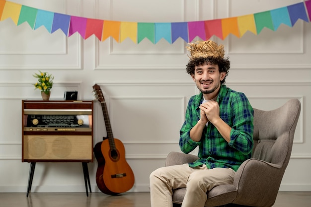 Festa junina lindo joven con sombrero de paja con radio retro y banderas coloridas tomados de la mano juntos