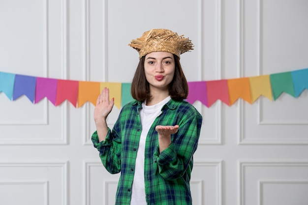 Festa junina niña bonita con sombrero de paja celebrando la fiesta brasileña enviando besos