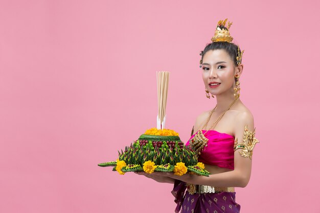 Festival de Loy Krathong. Mujer en traje tradicional tailandés sosteniendo decorado boyante