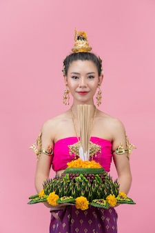 Festival de loy krathong. mujer en traje tradicional tailandés sosteniendo decorado boyante