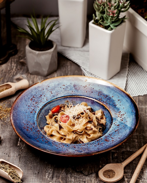 Fettuccine Alfredo con parmesano rallado de champiñones y tomate cherry