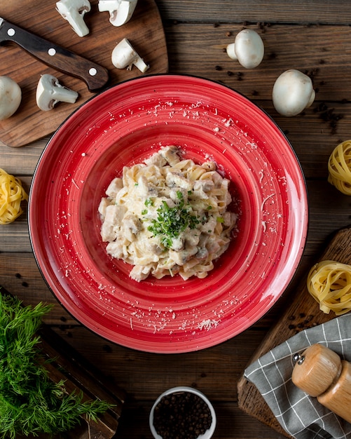 Foto gratuita fettuccine alfredo con pollo y champiñones parmesano y hebs