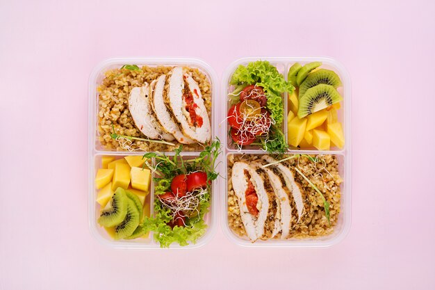 Fiambrera de pollo, bulgur, microgreens, tomate y fruta. Comida saludable y saludable. Para llevar. Caja de almuerzo. Vista superior