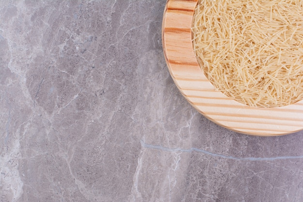 Fideos de arroz en una bandeja de madera sobre el mármol