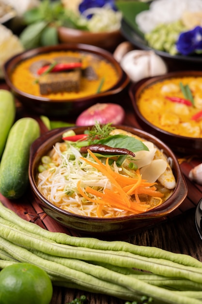 Fideos de arroz, curry rojo con albóndigas, con chiles secos, albahaca, pepino y habichuelas