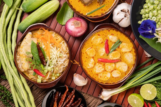 Fideos de arroz, curry rojo con albóndigas, con chiles secos, albahaca, pepino y habichuelas