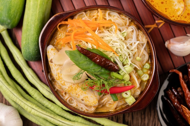 Fideos de arroz, curry rojo con albóndigas, con chiles secos, albahaca, pepino y habichuelas