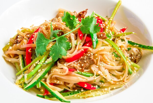 Fideos de arroz panasiáticos con carne de res, verduras, brotes de soja en salsa agridulce