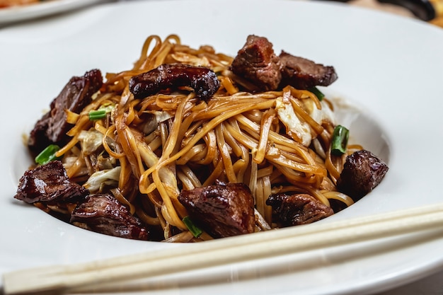 Foto gratuita fideos con carne verde salsa de champiñones vista lateral