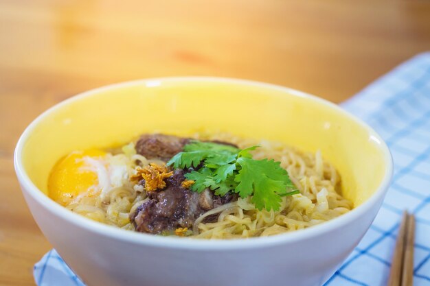 Fideos instantáneos con carne de cerdo y huevo listos para comer: concepto de menú de comida instantánea deliciosa