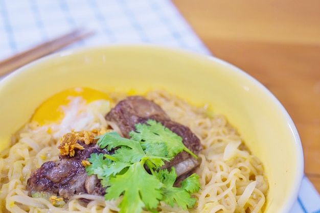 Fideos instantáneos con carne de cerdo y huevo listos para comer: concepto de menú de comida instantánea deliciosa