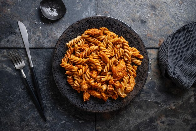 Fideos macarrones con carne y salsa de tomate servidos en un plato en la mesa