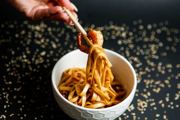 Fideos mezclados con champiñones y cubiertos con semillas de sésamo