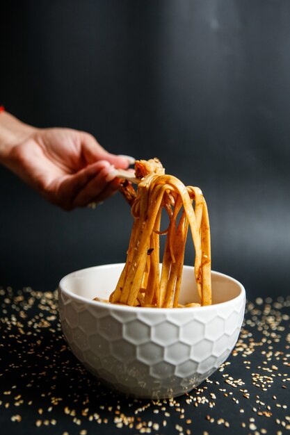 Fideos mezclados con champiñones y cubiertos con semillas de sésamo